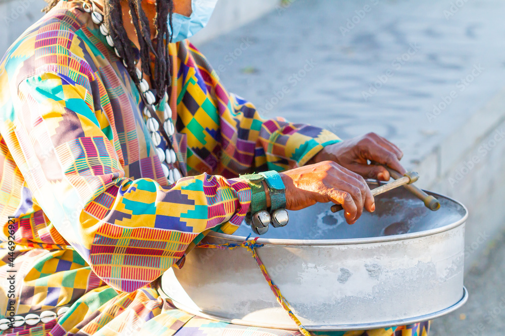 African musician playing percussion musical instrument in traditional African clothing. African musician playing percussion musical instrument in traditional African clothing.
