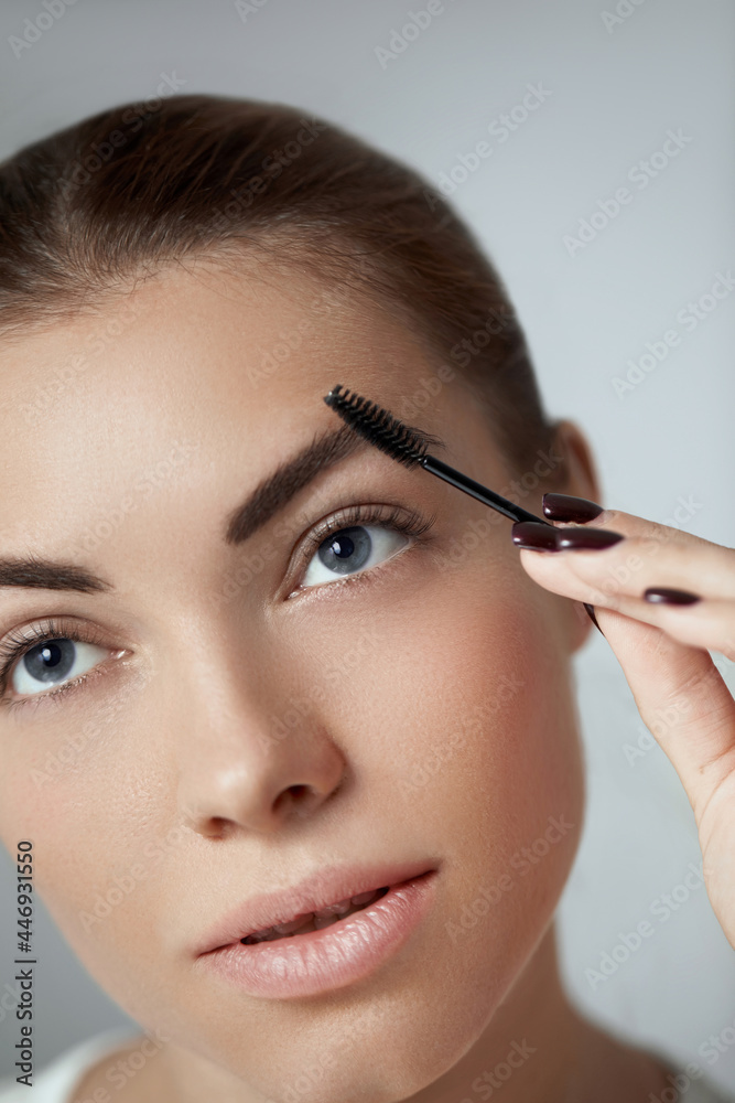 Young beautiful woman correcting shape of eyebrows. Contouring Eyebrow makeup .