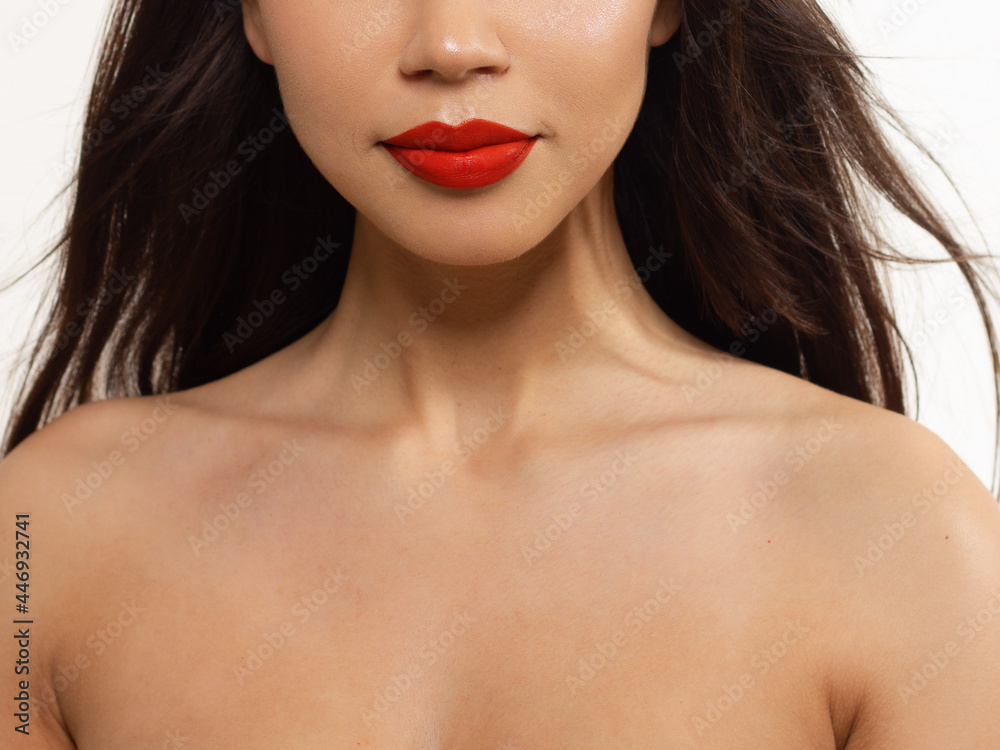 Cosmetics, makeup and trends. Bright lip gloss and lipstick on lips. Closeup of beautiful female mouth with natural lip makeup. Beautiful part of female face. Perfect clean skin in red light