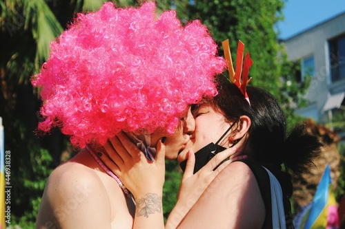 Two girls / young women / lesbian couple in love kissing each other in lgbtq pride parade *2