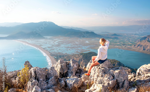 Fototapeta Naklejka Na Ścianę i Meble -  Young girl tourist looking at Iztuzu Beach and Dalyan panorama view from mountain