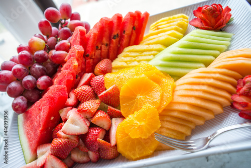 Freshly cut summer fruit displayed on a tray photo