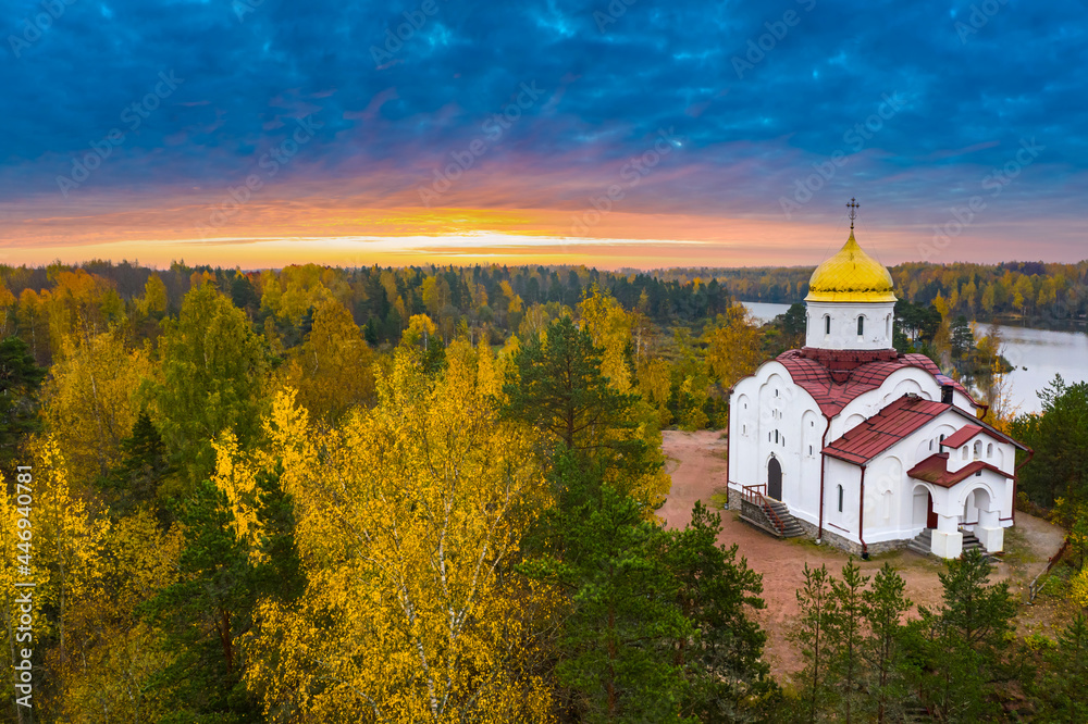 Landscape of Karelia. Churches of Russia. Church of St. George Victorious in Karelia. Orthodox church in autumn forest. Temple on background of sunset. Nature near Ruskeala Park. Forest in Russia.