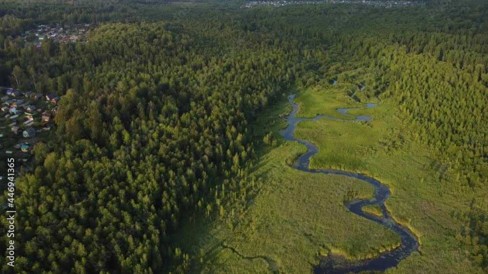 Smooth aerial dolly in over curved river in wood near the town Smooth aerial dolly in over curved river in wood near the town