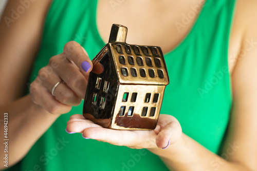 Woman holding a house in her hands real estate concept