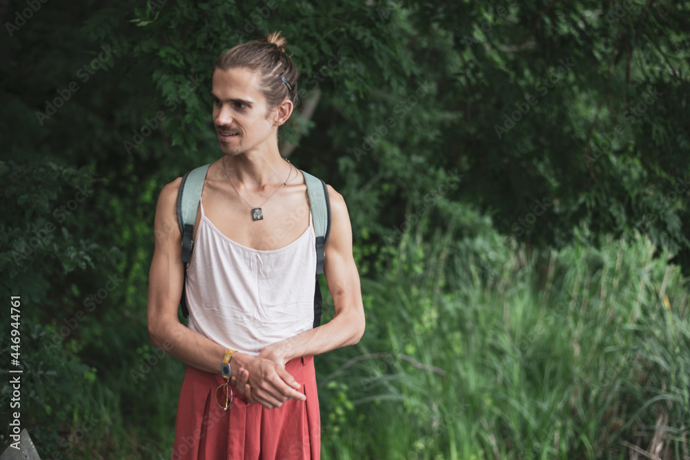 Young athletic non-binary man wearing backpack in forrest in Poland Young athletic non-binary man wearing backpack in forrest in Poland