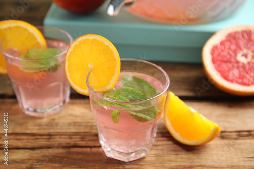 Delicious refreshing drink with orange and mint on wooden table