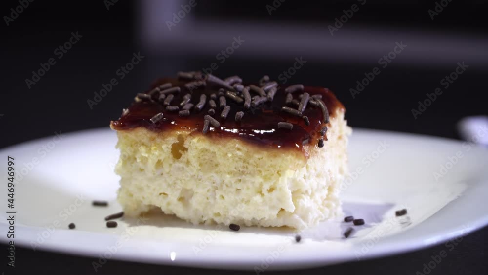 Adding chocolate sprinkle on plate of tiramisu cake decorated in a restaurant Adding chocolate sprinkle on plate of tiramisu cake decorated in a restaurant