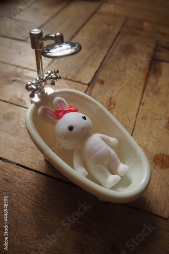 Malutka zabawka biały króliczek w miniaturowej wannie 