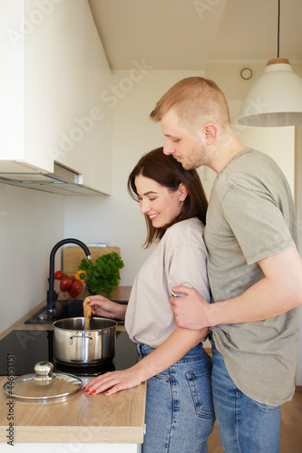 portrait of young couple cooking something at home