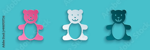 Paper cut Teddy bear plush toy icon isolated on blue background. Paper art style. Vector