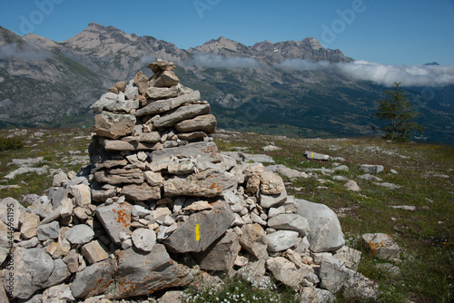pile of stones or cairn , in the French alps with mountain tops and clouds in distance. © robert