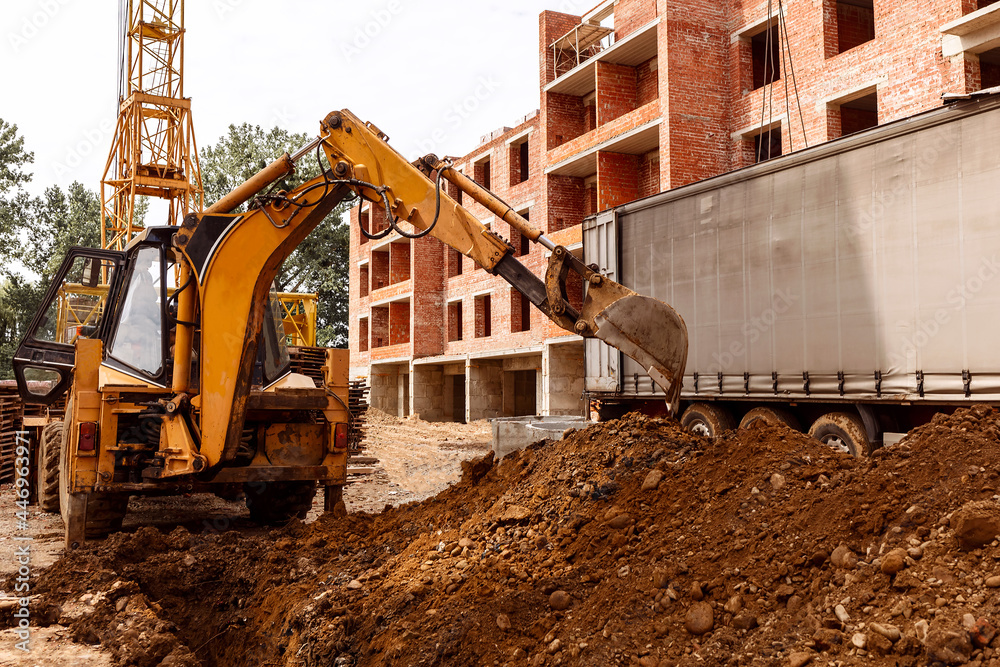 An excavator unrolls a pile of earth. Work on the construction site An excavator unrolls a pile of earth. Work on the construction site
