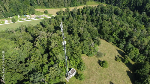 Pappenheim, Germany  Bavaria - August 1, 2021: Wide Area Network (WAN) 3G 4G 5G LTE mobile radio broadband transceiver communications tower with, trees, srubs , and view from above. photo