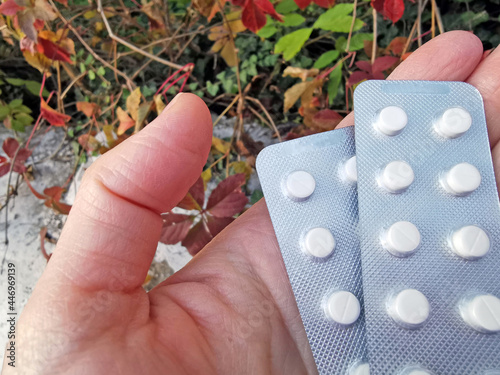 White tablets in a silver blister in hand close-up. The concept of drug treatment photo