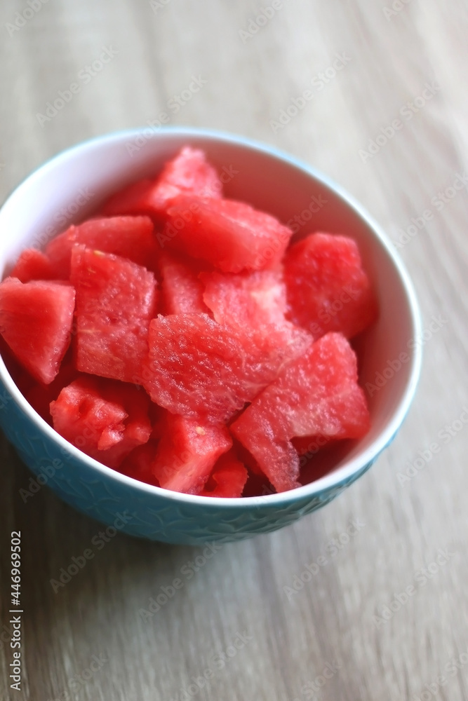 Bowl of watermelon cubes on wooden table. Selective focus. Bowl of watermelon cubes on wooden table. Selective focus.