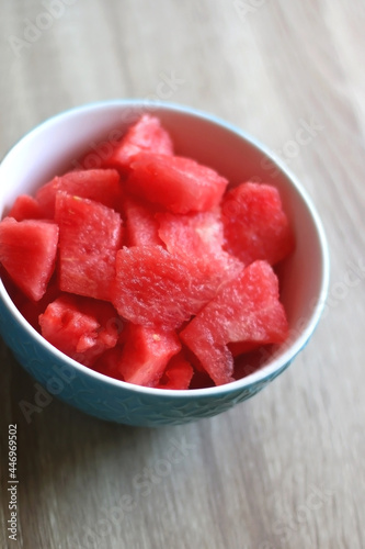 Bowl of watermelon cubes on wooden table. Selective focus.