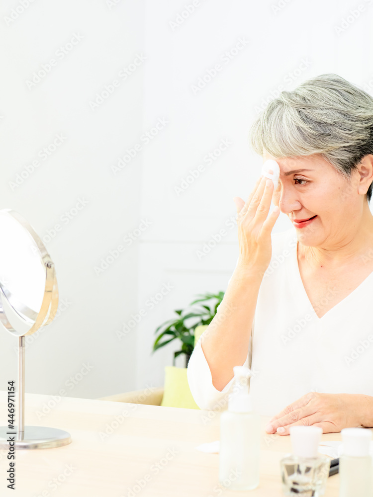 Portrait of beautiful senior asian woman applying powder puff at cheek makeup of cosmetic. Portrait of beautiful senior asian woman applying powder puff at cheek makeup of cosmetic.