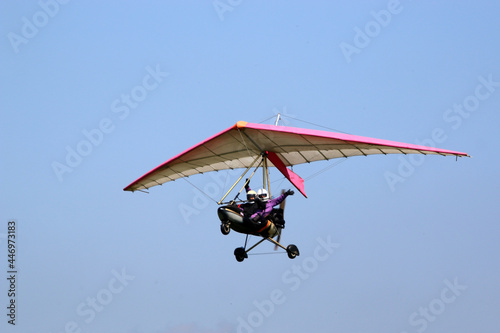 	
Ultralight airplane flying in a blue sky	
