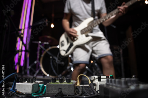 Close-up set of distortion effect pedals for guitar on stage.