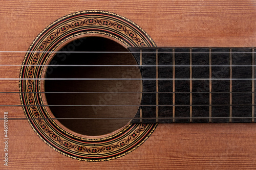 Fotografie Close-up of old acoustic guitar showing detail of decorative rosette decal around soundhole, strings and part of ebony fretboard