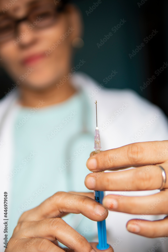 Close-up female doctor holding injection in hand. Close-up female doctor holding injection in hand.