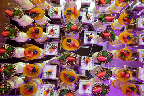 Beautiful and bright desserts on the festive table for the party. Confectionery with cream