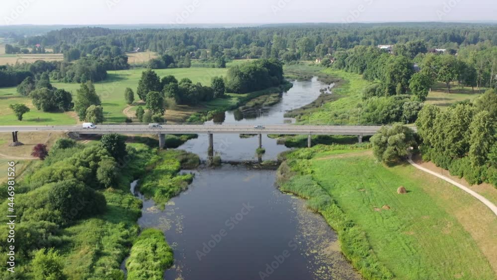 Aerial orbiting view of cars driving over bridge. River flowing under bridge Aerial orbiting view of cars driving over bridge. River flowing under bridge