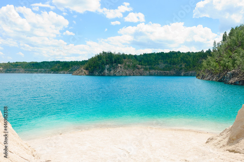 Clean white sandy beach of a beautiful blue forest lake. Summer, noon, vacation