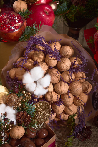Gift for Christmas, a set-bouquet of walnuts, chocolate, cones and pomegranates © AlexLit