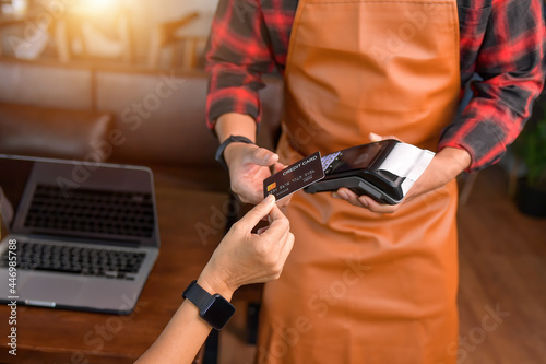 Close up of hand using credit card swiping machine to pay