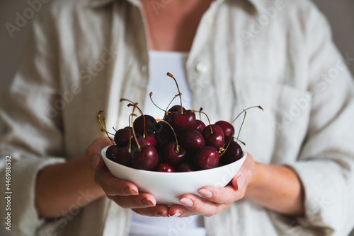 Midsection of woman holding plate cherries photo