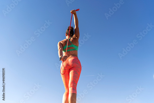 woman doing stretching outdoors with rubber bands