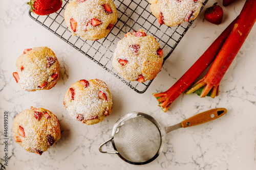 Fotografía Strawberry Rhubarb muffins on tray dusted with powdered sugar