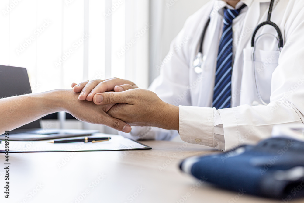 The doctor shakes hands to encourage the patient after the diagnosis