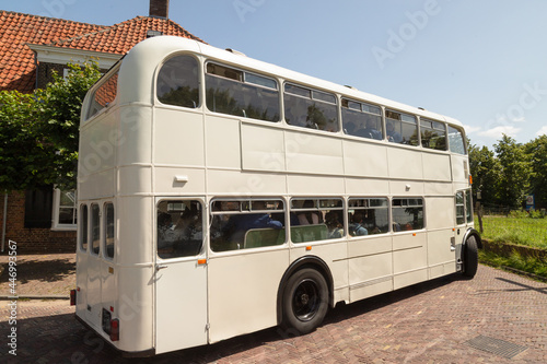 White high double decker bus rides over the narrow dike through the picturesque Fototapet