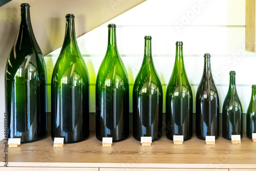 Different types of green glass champagne sparkling wine bottles from smallest to biggest photo