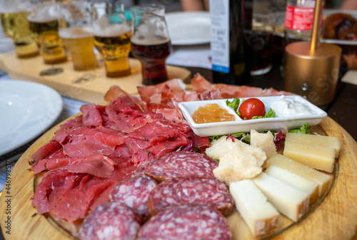 An appetizing platter of cold cuts and assorted cheeses with Trentino specialties such as speck, to accompany sauces. Concept of typical and healthy Italian food