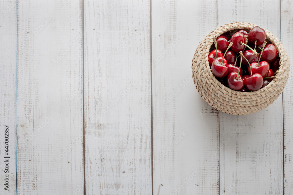sweet cherries on a wooden background in a wicker basket