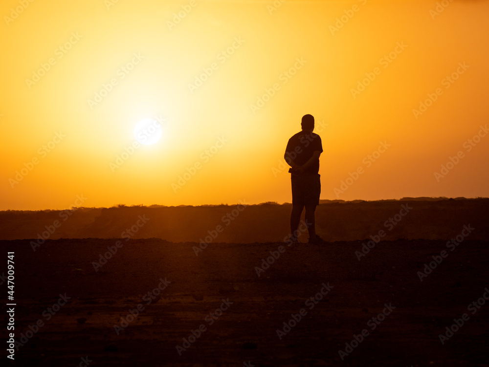 Man Looking the Sunrise in the Desert at Punta Gallinas, with a Yellow Sky in La Guajira, Colombia
