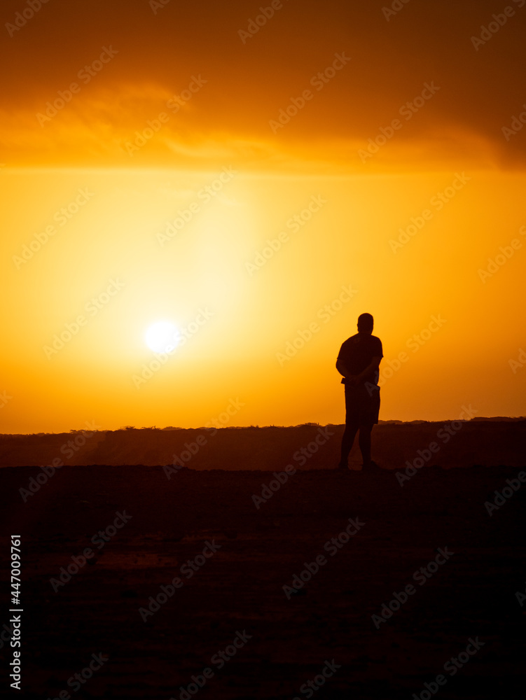 Man Looking the Sunrise in the Desert at Punta Gallinas, with a Yellow Sky Full of Clouds in La Guajira, Colombia