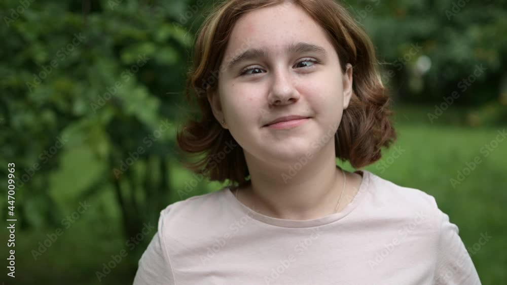 A teenage girl makes funny faces at the camera in the park. Foolishness and fun. A teenage girl makes funny faces at the camera in the park. Foolishness and fun.