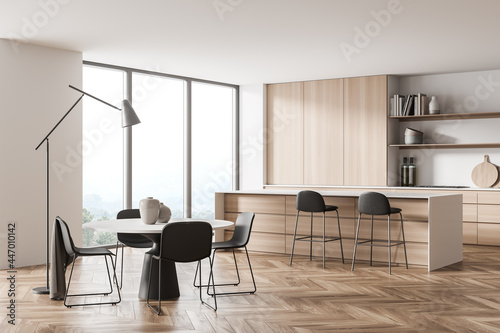 Light white kitchen space with round dining table. Corner view