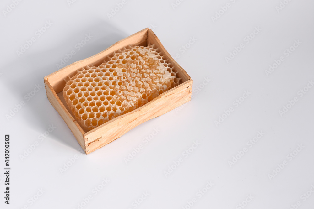 honeycomb with bee honey in a wooden box. close-up on a white background. a natural product of healthy nutrition. honeycomb with bee honey in a wooden box. close-up on a white background. a natural product of healthy nutrition.