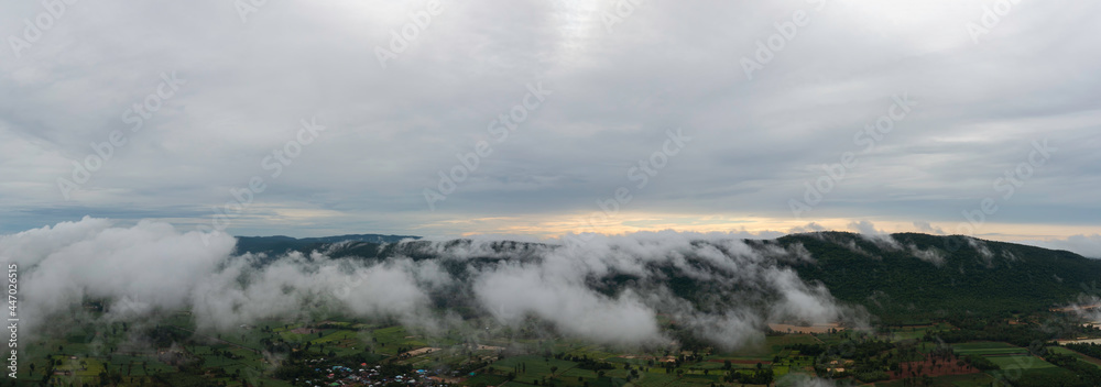 Aerial view Sunrise Beautiful sky with fog clouds. Fantastic foggy landscape glowing while sunrise in the morning. A beautiful landscape with high mountains foggy cover. Dense fog with beautiful light
