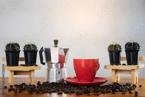 Making hot coffee on wooden table. Espresso coffee and coffee beans with cactus background show on table relaxing concept of the day.