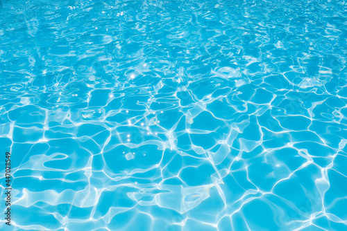 Blue water surface in swimming pool with sun reflection, Ripple wave in pool for background and abstract