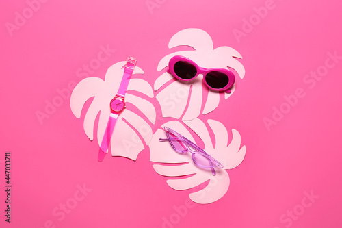 Composition with stylish sunglasses  wrist watch and paper palm leaves on color background