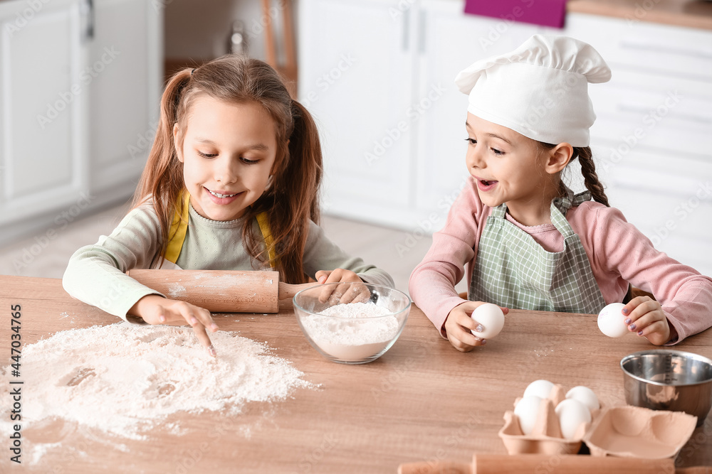 Cute little sisters cooking in kitchen Cute little sisters cooking in kitchen