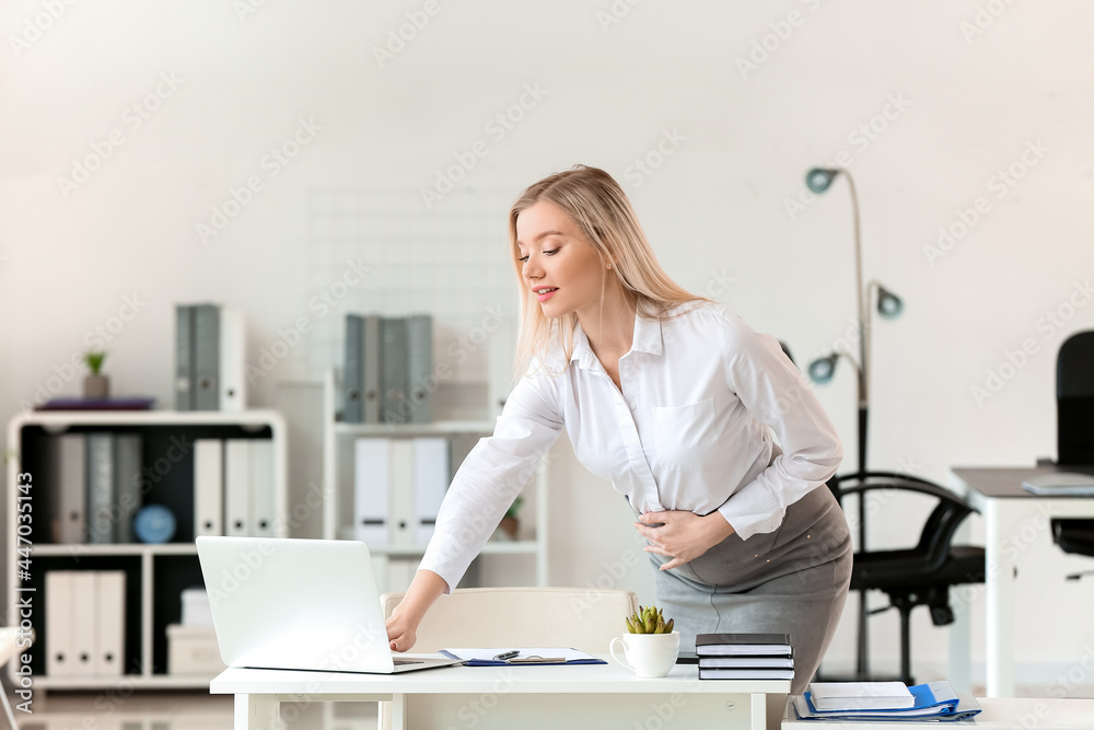 Pregnant businesswoman working with laptop in office Pregnant businesswoman working with laptop in office